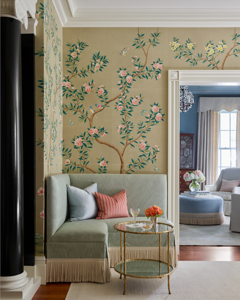blue corner setee with bullion fringe, a gold bamboo side table, and chinoiserie wallpaper in a traditional isle of hope georgia home