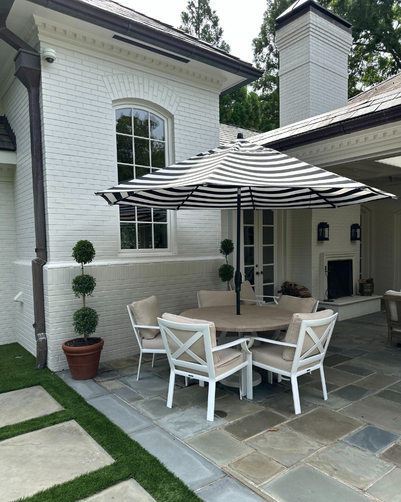 covered patio with a fireplace and umbrella dining table