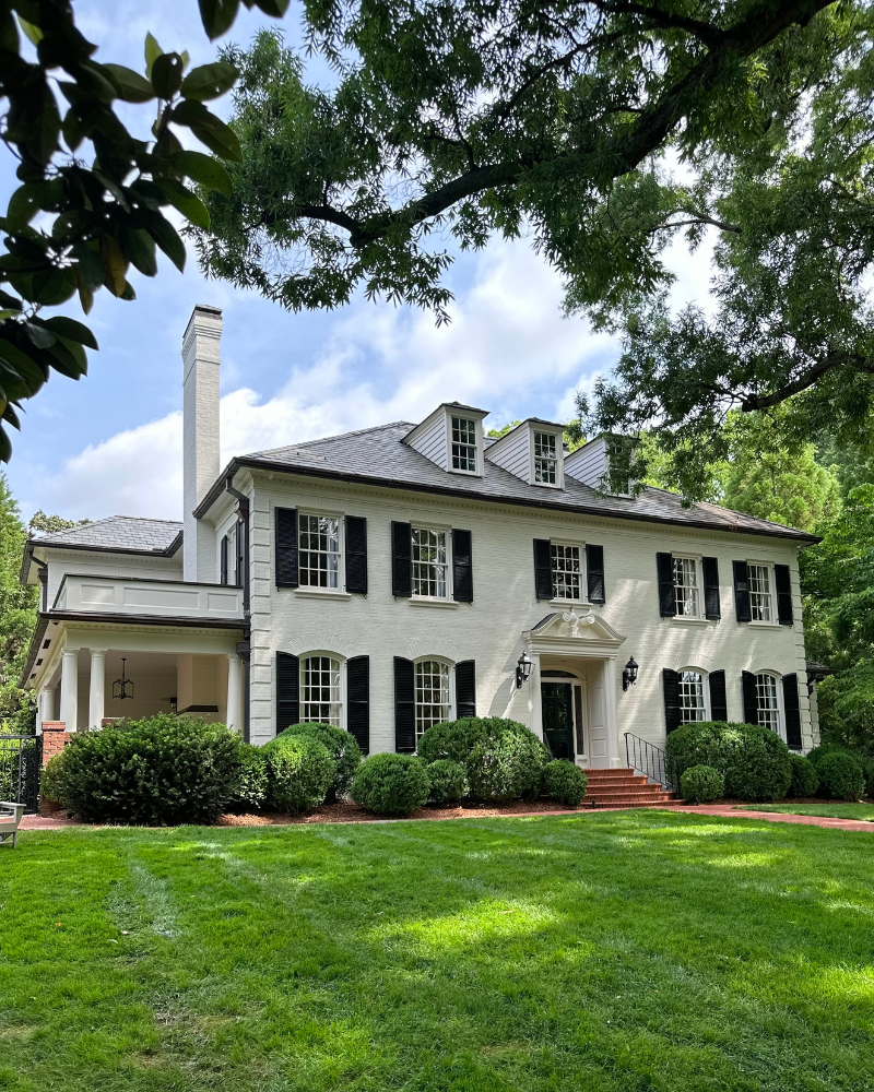 classic colonial white brick home in the Eastover neighborhood of Charlotte with black shutters