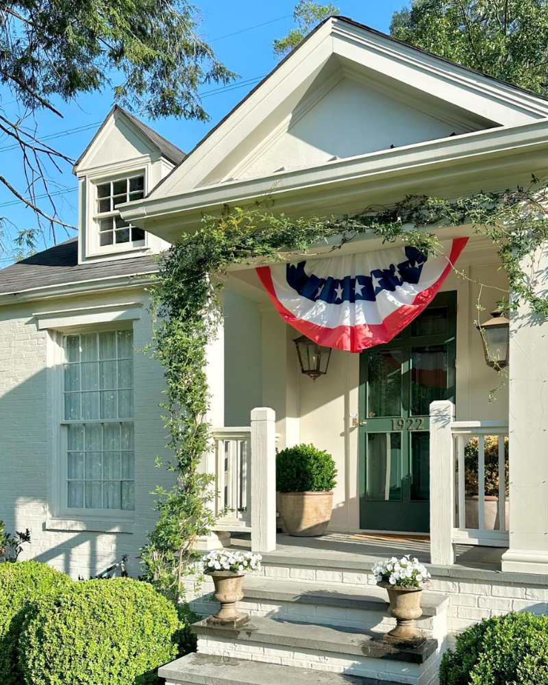 We love Lauren Elaine Interiors’ classic brick bungalow. Benjamin Moore Natural Cream serves as the backdrop that allows the Tarrytown Green front door to shine.