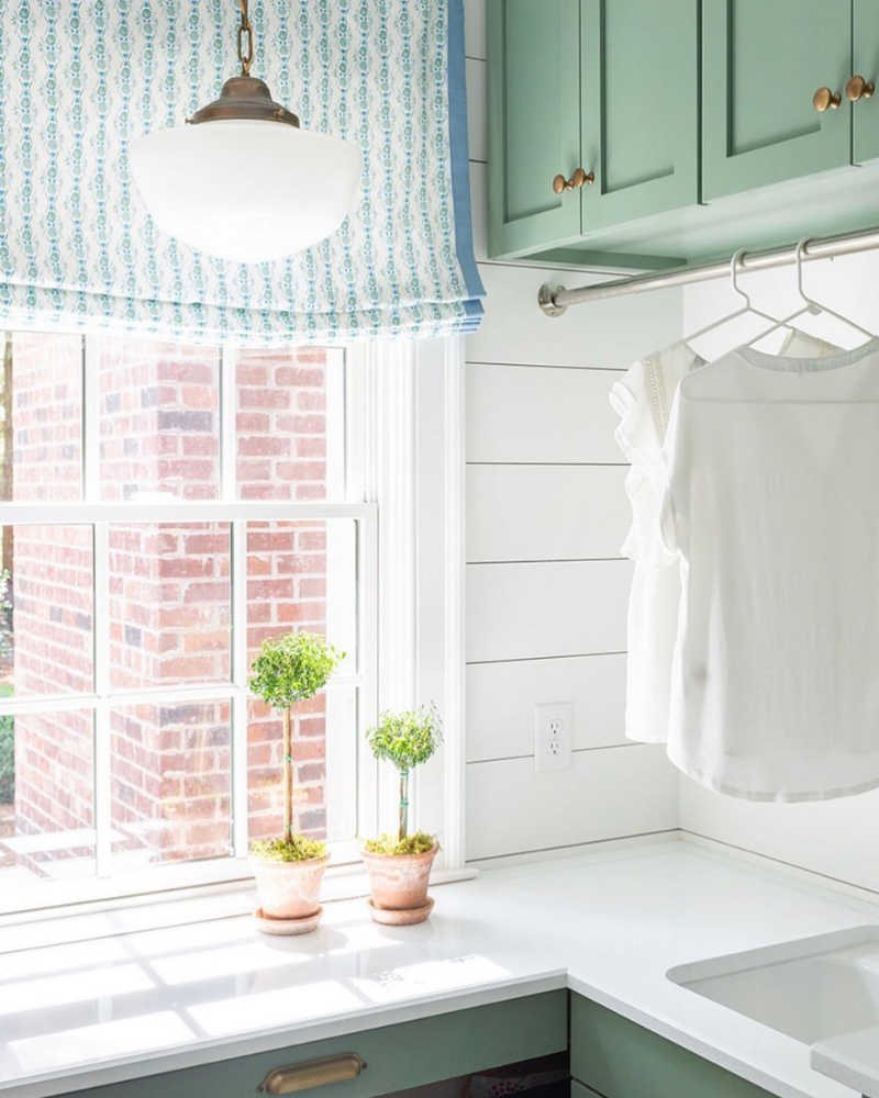 potted classic topiary featured in a traditional green laundry room